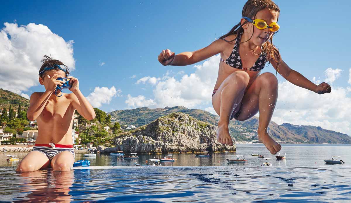 kids jumping in the pool taking photos of each other at a pool at the belmond in italy