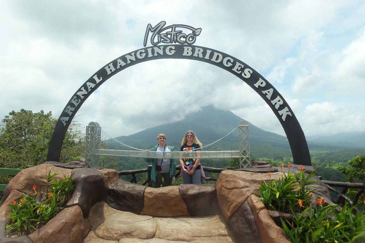 Julie Goergen and friend underneath the Mistico Arenal hanging bridges park arch